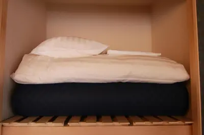 a bed with white sheets and pillows on a shelf at Sakura Stay Yoga 301 in Tokyo