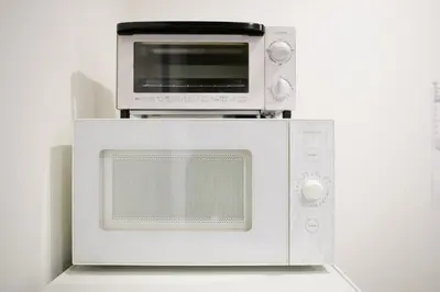 a white microwave with a toaster oven on top of it at Sangen-jaya House-O in Tokyo