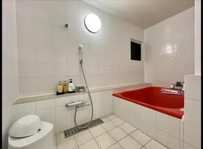 a bathroom with a red tub and a toilet at Hotel Asian Color (Adult Only) in Tokyo