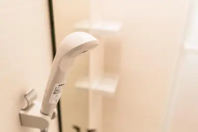 a white electric toothbrush hanging from a mirror at Bunkyo-ku - Apartment / Vacation STAY 4147 in Tokyo