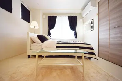 a bedroom with a bed and a table and a window at Three Tokyo 101 in Tokyo
