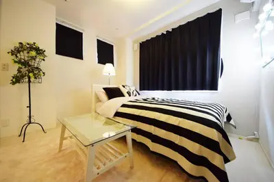 a bedroom with a bed and a table and a window at Three Tokyo 101 in Tokyo