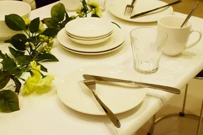 a white table with white plates and glasses on it at Three Tokyo 101 in Tokyo