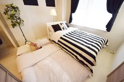 a bedroom with a black and white bed and a window at Three Tokyo 101 in Tokyo