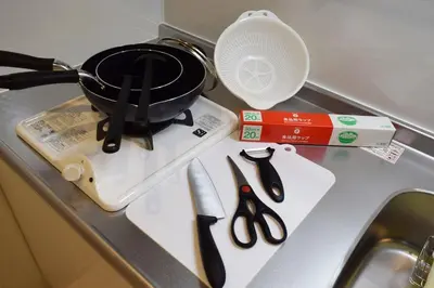 a frying pan sitting on a stove with scissors at Three Tokyo 102 in Tokyo