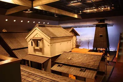 a model of a house and a lighthouse in a museum at Three Tokyo 102 in Tokyo