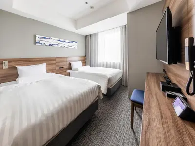 a hotel room with two beds and a flat screen tv at Far East Village Hotel Tokyo Ariake in Tokyo
