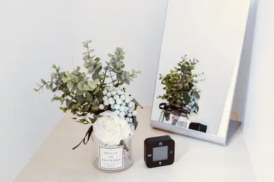 a vase with flowers on a table next to a mirror at Alo BnB 5 - Near NIPPORI, SENDAGI, YANAKA GINZA, UENO - Self check-in in Tokyo