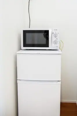 a microwave sitting on top of a white refrigerator at Alo BnB 5 - Near NIPPORI, SENDAGI, YANAKA GINZA, UENO - Self check-in in Tokyo