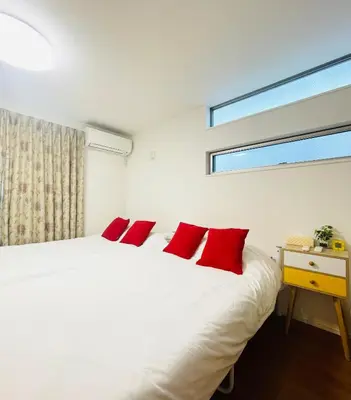 a bedroom with a white bed with red pillows at Alo BnB 5 - Near NIPPORI, SENDAGI, YANAKA GINZA, UENO - Self check-in in Tokyo