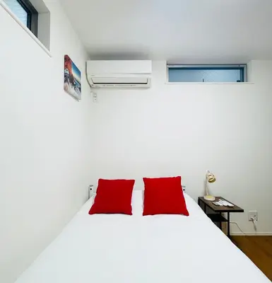 a bedroom with a white bed with two red pillows at Alo BnB 5 - Near NIPPORI, SENDAGI, YANAKA GINZA, UENO - Self check-in in Tokyo