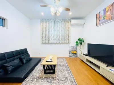 a living room with a black leather couch and a flat screen tv at Alo BnB 5 - Near NIPPORI, SENDAGI, YANAKA GINZA, UENO - Self check-in in Tokyo