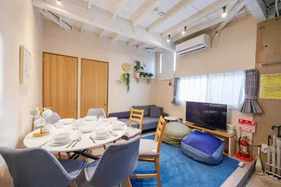 a living room with a table and chairs and a tv at SMILE STAY Shinnakano in Tokyo