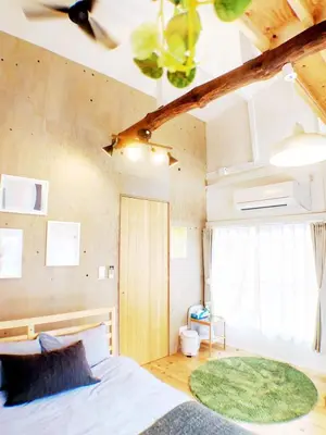 a bedroom with a large bed with a green rug at SMILE STAY Shinnakano in Tokyo