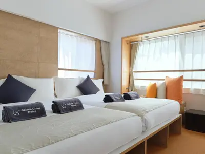 two beds sitting next to each other in a room at Sakura Cross Hotel Ueno Okachimachi in Tokyo
