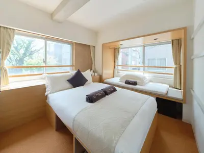 two beds in a small room with two windows at Sakura Cross Hotel Ueno Okachimachi in Tokyo