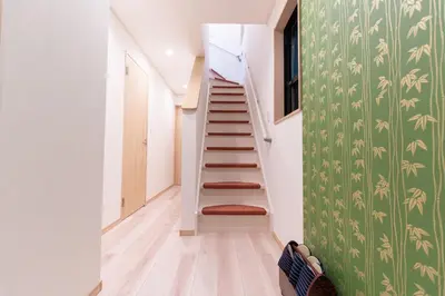 a staircase in a house with a green wall at CuteFamilyHouse! 8min Shinjuku 5minJR 3minSubway Cozy,Quiet KidsFree Under6yrs in Tokyo