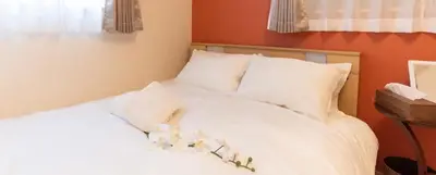 a bed with white sheets and pillows in a room at CuteFamilyHouse! 8min Shinjuku 5minJR 3minSubway Cozy,Quiet KidsFree Under6yrs in Tokyo
