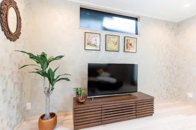 a living room with a flat screen tv and a plant at CuteFamilyHouse! 8min Shinjuku 5minJR 3minSubway Cozy,Quiet KidsFree Under6yrs in Tokyo