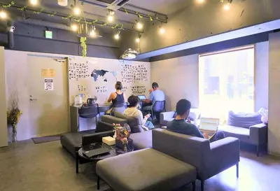a group of people sitting in a waiting room at &AND HOSTEL MINAMISENJU in Tokyo