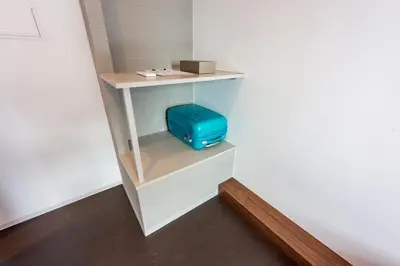 a blue suitcase sitting on a shelf in a room at &AND HOSTEL MINAMISENJU in Tokyo