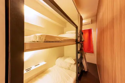 a bedroom with two bunk beds in a room at &AND HOSTEL MINAMISENJU in Tokyo