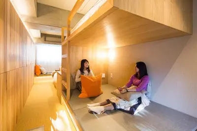 two women sitting on the floor in a room at Sakura Cross Hotel Tokyo Kayabacho in Tokyo