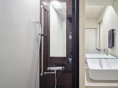 a bathroom with a sink and a toilet and a shower at Sakura Cross Hotel Tokyo Kayabacho in Tokyo