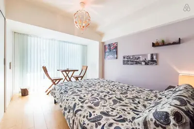 a bedroom with a bed and a table and a window at Shibuya Lions Mansion#1DK in Tokyo