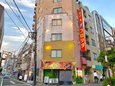 a tall building with a sign for a hotel at Tabist Hotel Florida Ikebukuro in Tokyo