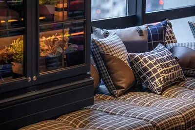a couch with pillows sitting next to a window at THE LIVELY TOKYO AZABUJUBAN in Tokyo