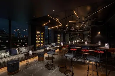 a restaurant with a bar with stools and a couch at THE LIVELY TOKYO AZABUJUBAN in Tokyo