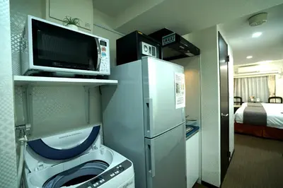 a kitchen with a washer and a microwave and a tv at Le Tour Hotel Akihabara Ekimae \u697d\u9014\u30db\u30c6\u30eb\u79cb\u8449\u539f\u99c5\u524d\u5e97 in Tokyo