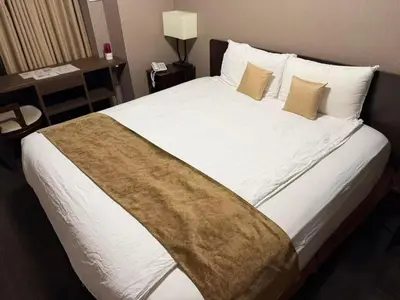 a bedroom with a large bed with white sheets and pillows at Le Tour Hotel Akihabara Ekimae \u697d\u9014\u30db\u30c6\u30eb\u79cb\u8449\u539f\u99c5\u524d\u5e97 in Tokyo
