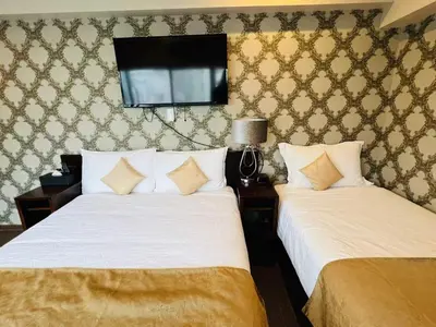 a bedroom with two beds and a tv on the wall at Le Tour Hotel Akihabara Ekimae \u697d\u9014\u30db\u30c6\u30eb\u79cb\u8449\u539f\u99c5\u524d\u5e97 in Tokyo