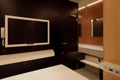 a bathroom with a large tv on a black wall at hotel min \u5927\u4eba\u5c02\u7528 in Tokyo