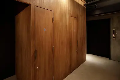 a hallway with wooden panels in a room with a door at hotel min \u5927\u4eba\u5c02\u7528 in Tokyo
