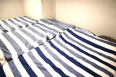 a bed with blue and white stripes on it at Building A101 / Vacation STAY 1274 in Tokyo