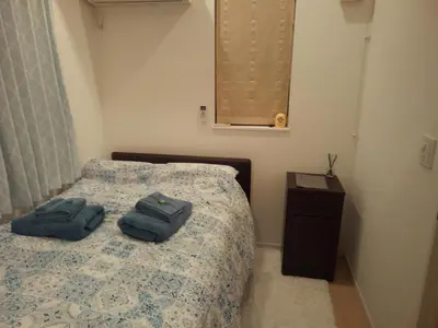 a bedroom with a bed with two blue towels on it at Private room in new House in Tokyo