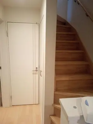 a staircase with a white door and wooden stairs at Private room in new House in Tokyo