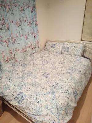 a bedroom with a bed with a blue and white quilt at Private room in new House in Tokyo