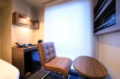 a room with a desk and a chair and a table at Quintessa Hotel Tokyo Ginza in Tokyo