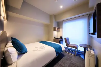 a hotel room with a bed and a chair at Quintessa Hotel Tokyo Ginza in Tokyo