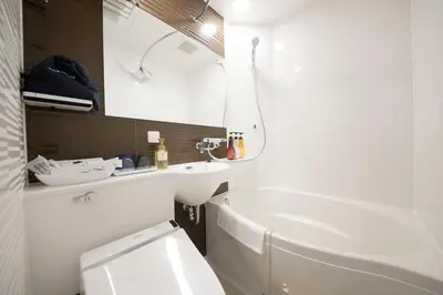 a bathroom with a toilet and a sink and a tub at Quintessa Hotel Tokyo Ginza in Tokyo