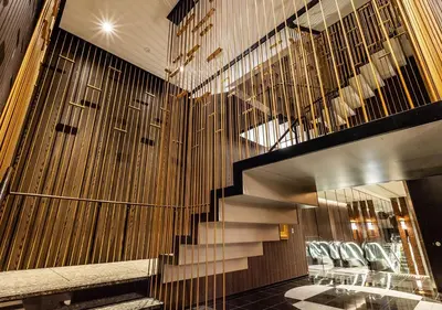 a lobby with a staircase and chairs in a building at APA Hotel & Resort Ryogoku Ekimae Tower in Tokyo