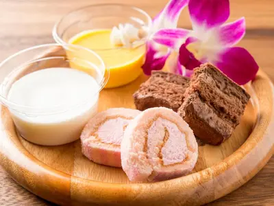a wooden plate with bread and butter and flowers at \u30db\u30c6\u30eb \u30d7\u30c6\u30a3\u30d0\u30ea\u30ac\u30fc\u30c7\u30f3\u65b0\u5927\u4e45\u4fdd in Tokyo