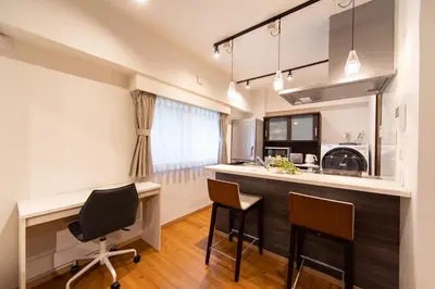 a kitchen with a bar with chairs and a desk at NIYS apartments 03 type in Tokyo