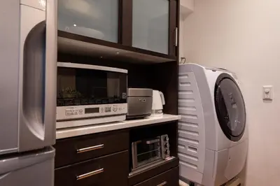 a kitchen with a microwave and a refrigerator at NIYS apartments 03 type in Tokyo