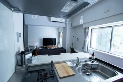 a kitchen with a sink and a living room at NIYS apartments 03 type in Tokyo