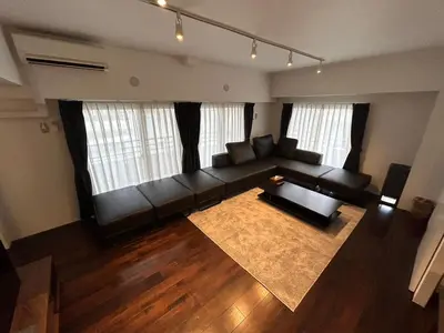 a living room with a black couch and a rug at NIYS apartments 0074 type in Tokyo